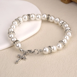 Détails du bracelet en perles avec espaceurs en strass argentés et pendentif croix
