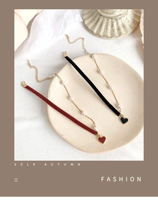Detailed view of velvet heart choker necklaces with pearls in red and black colors