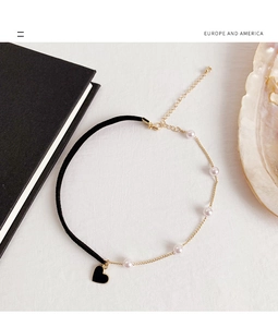 Detail of velvet and gold chain choker necklace with pearls and black heart pendant