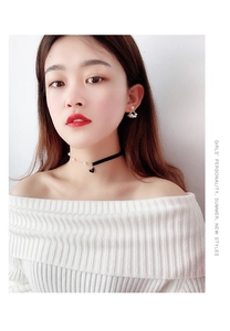 Detail shot of heart pendant choker with pearls and matching floral earrings on model