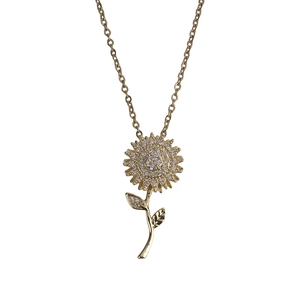 Dettaglio della collana con ciondolo a girasole rotante con zirconi e finitura oro