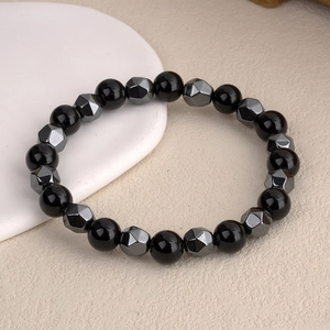 Faceted hematite and tiger eye beaded bracelet for men and women on white ceramic plate