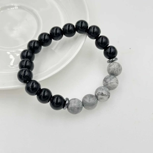 Dettaglio delle perle di pietra lavica nera e perle in marmo grigio su questo bracciale