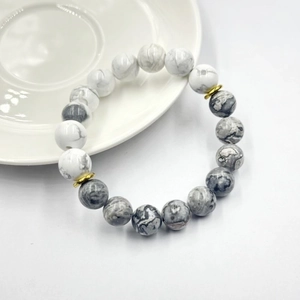 Dettaglio del bracciale in pietra vulcanica con perle di marmo bianco e inserti dorati