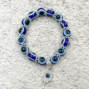 Bracciale occhio di Allah blu con ciondolo Mano di Fatima in argento su sfondo grigio