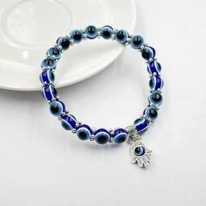 Dettaglio del bracciale con perline occhio blu e ciondolo in argento della Mano di Fatima