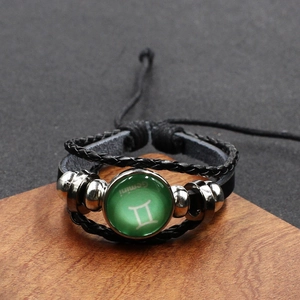Detail des Gemini-Sternzeichens auf grünem Glasstein mit schwarzem Lederarmband