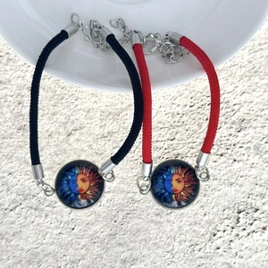 Dettaglio di braccialetti intrecciati sole e luna con catene d'argento e chiusure a moschettone