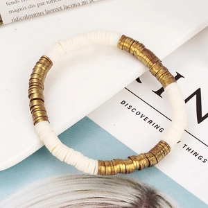 Detail van bohemien crèmewitte polymeerklei schijfkralen met vintage gouden metalen spacers