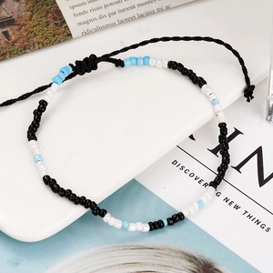 Handmade Bohemian woven string bracelet with colorful seed beads in blue black and white