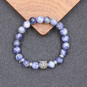 Détail du bracelet de yoga en perles de turquoise avec breloque chouette en argent vieilli