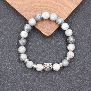 Détail de la perle chouette et des pierres naturelles sur un bracelet de yoga argent
