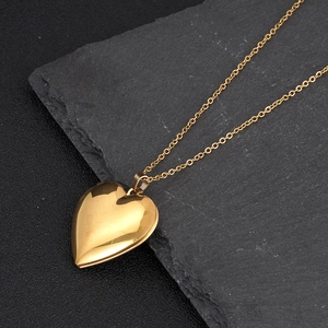 Detalle de un colgante guardapelo de corazón en oro pulido con un acabado muy elegante