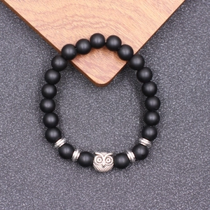 Vue détaillée de la perle hibou et des billes noires mates sur bracelet de yoga