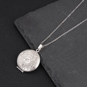 Detalle de relicario de plata con grabado floral sobre una superficie de piedra