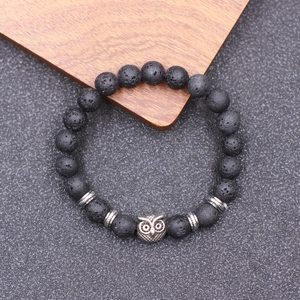 Vue détaillée des perles de lave noire et du pendentif hibou en argent antique du bracelet