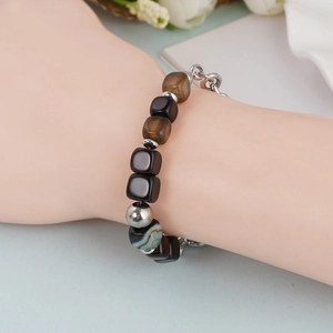 Detail van vintage kralenarmband met agaatsteen en metalen ketting om de pols