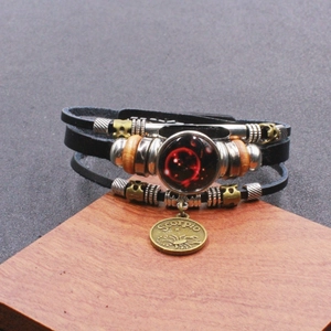 Dettaglio del bracciale multistrato in pelle Scorpione con ciondolo zodiacale in ottone