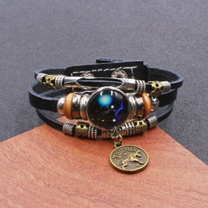 Dettaglio del bracciale in pelle multistrato zodiaco con ciondolo Toro e motivo a stelle