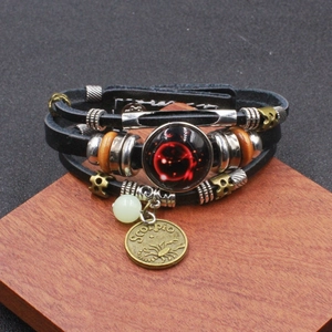 Dettaglio del bracciale Scorpione multistrato in pelle con ciondoli in bronzo incisi