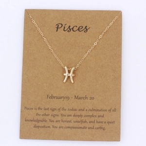 Collar dorado con colgante de Piscis presentado en una tarjeta de exhibición minimalista