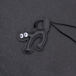 Minimalist black faux leather cat charm for bags and keychains with white round eyes