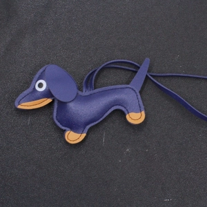 Handmade dachshund leather bag charm in dark purple with brown accents and long lanyard
