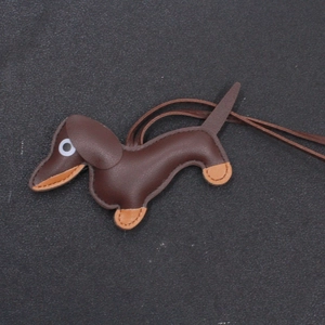 Detailed close-up of brown and orange handmade leather dachshund bag charm with stitching