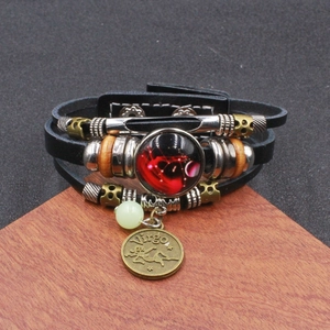 Dettaglio di un bracciale multistrato in pelle con segno della Vergine e perla luminosa