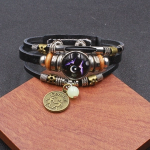 Vista macro del bracciale multistrato Gemelli in pelle con ciondolo in bronzo e vetro inciso