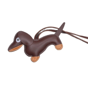 Handmade brown leather dachshund dog bag charm with detailed stitching on white background
