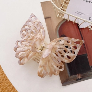 Macro detail of large marble-patterned butterfly hair claw clip with cutout design