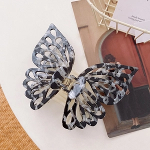 Detail of a large butterfly hair claw clip with black and white marble pattern texture