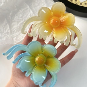 Lot de deux pinces à cheveux fleurs de frangipanier dégradées orange et bleues