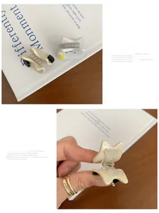 Détail de petites pinces à cheveux dents avec étoiles jaunes et nœud crème sur livre