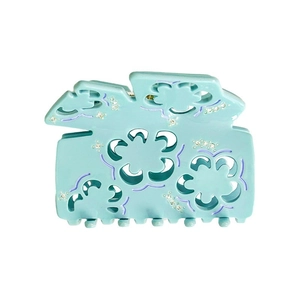 Macro view of mint green acetate hair claw clip with purple trim and rhinestone rhinestones