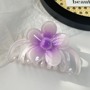 Détail d'une pince à cheveux fleur de frangipanier violette dégradée en résine translucide