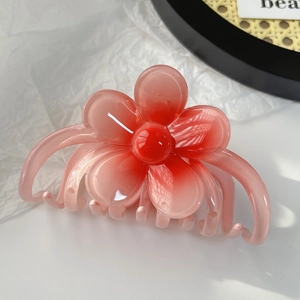 Détail de la pince à cheveux fleur de frangipanier rose dégradé en résine brillante