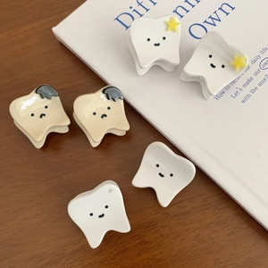 Pinces à cheveux mignonnes en forme de dent avec motifs d'étoiles sur table en bois