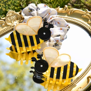 Macro shot of acetic bee hair claws and floral scrunchie on a vintage mirror