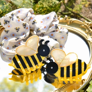 Acetate bumblebee hair claw clip and daisy print scrunchie set on a vintage mirror