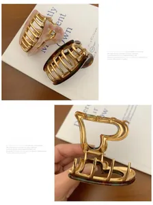 Macro detail of heart-shaped acetate claw clips with marble texture and gold metal frame