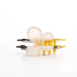 Detail view of large acetate bee hair claw clip with rhinestones and striped body