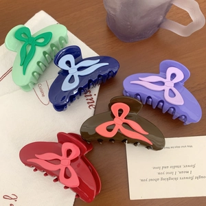 Lot de 5 pinces à cheveux à nœuds colorés pour femmes sur une table en bois