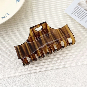 Detailed macro view of amber brown heart cutout acetate hair claw with tortoiseshell texture