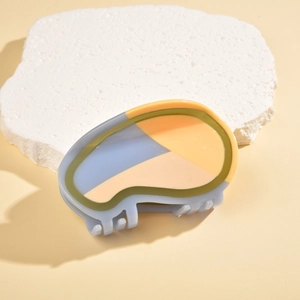 Detail of a geometric acetate claw clip with translucent blue, yellow, and green拼接 colors