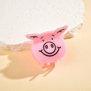 Close-up of cute pink pig hair claw clip made of acetate resin on a white stone base