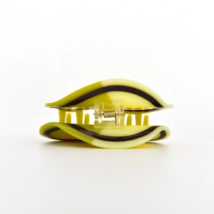 Macro shot of avocado green wavy patterns on acetate hair claw clip with metal spring detail