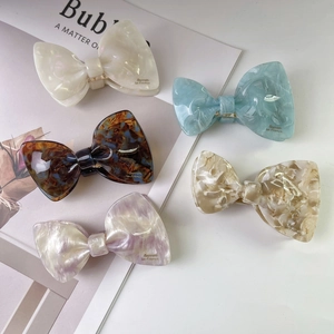 Elegant acetate bow hair clips in assorted marble patterns for women's hair styling