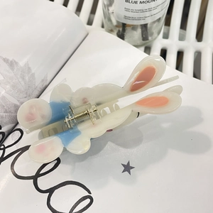 Détail d'une pince à cheveux oreilles de lapin en acétate crème avec ressort doré